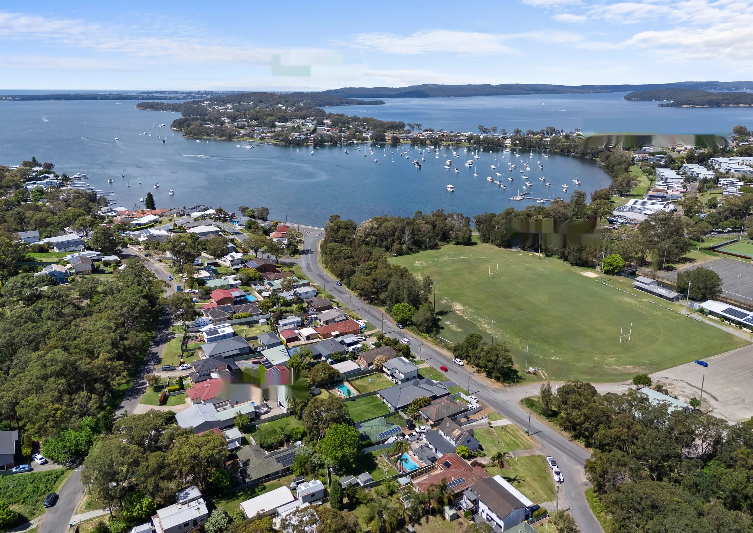 Aerial view showing 32 Fern Street, Wangi Oval, the Wangi District Workers Club, Wangi shops and Lake Macquarie